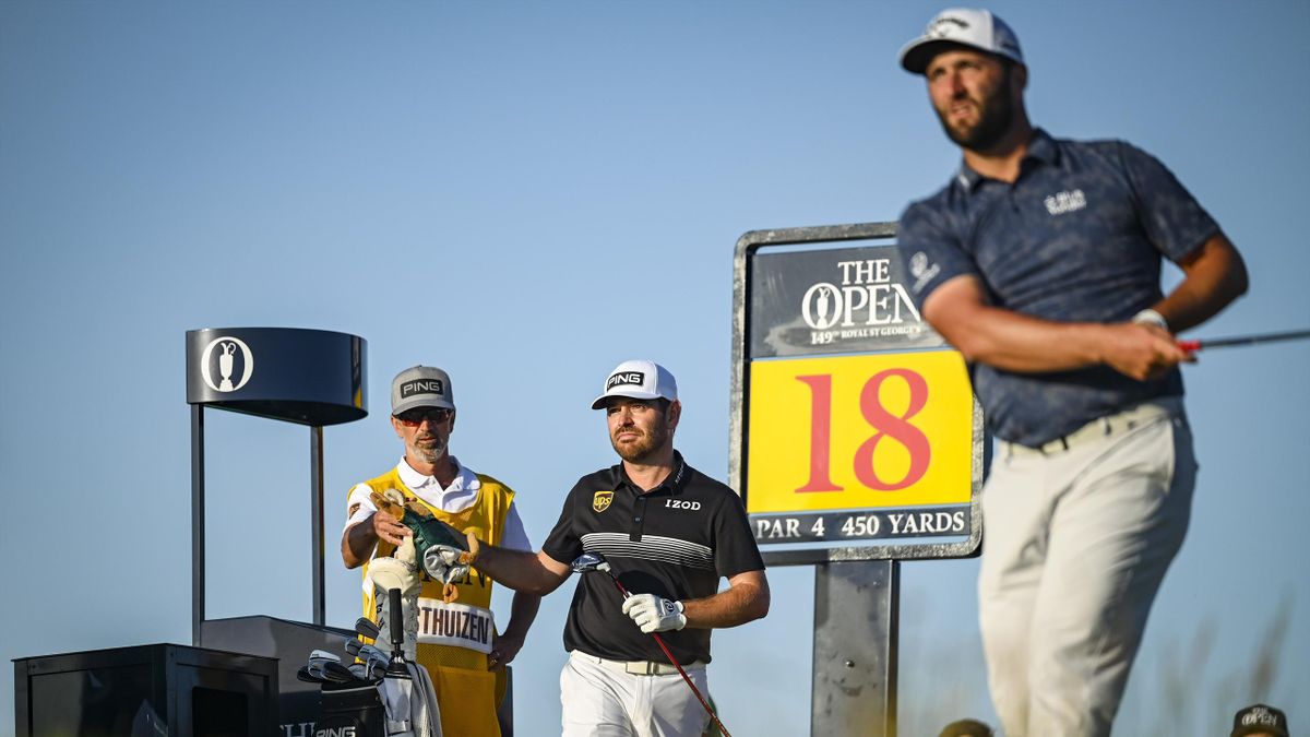 Jon Rahm of Spain plays his shot from the 18th tee as Louis Oosthuizen of South Africa looks on during Day Two of the 149th The Open Championship at Royal St. Georges Golf Club on July 16, 2021 in Sandwich, England.