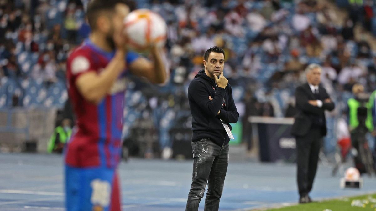 Xavi mira atentamente el partido de la Supercopa entre Barcelona y Real Madrid