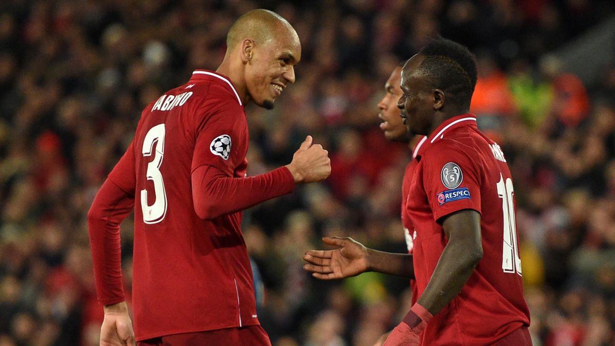Liverpool's Senegalese striker Sadio Mane (R) celebrates with Liverpool's Brazilian midfielder Fabinho (L) after scoring their fourth goal during the UEFA Champions League group C football match between Liverpool and Red Star Belgrade at Anfield in Liverp