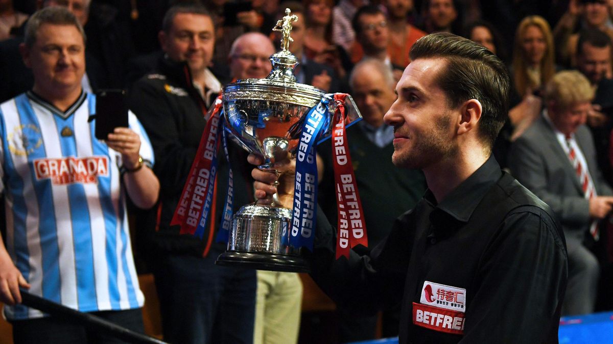 England's Mark Selby celebrates with the trophy after beating Scotland's John Higgins in the World Championship Snooker final at The Crucible in Sheffield
