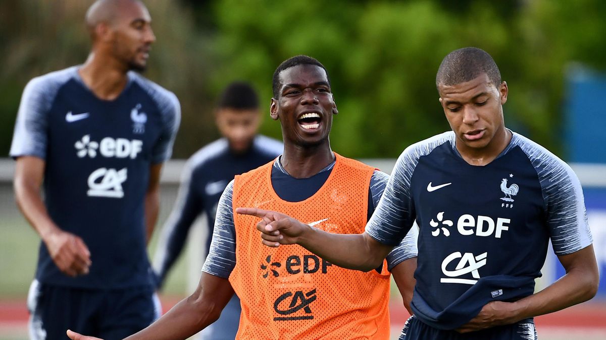 France's midfielder Paul Pogba (C) jokes with France's forward Kylian Mbappe at the end of a training session in Clairefontaine en Yvelines on May 30, 2018, as part of the team's preparation for the upcoming FIFA World Cup 2018 in Russia.