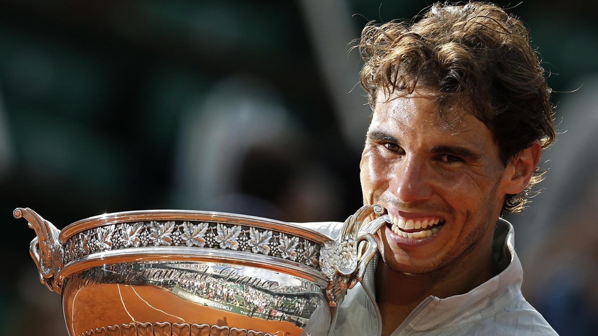 Rafael Nadal bites the trophy after winning the men's singles final of the French Open tennis tournament against Novak Djokovic, in Paris, France.