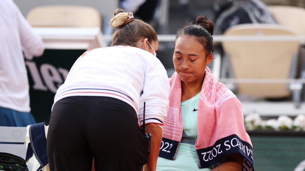 Qinwen Zheng of China talks with a physio on court against Iga Swiatek of Poland during the Women's Singles Fourth Round match on Day 9 of The 2022 French Open at Roland Garros on May 30, 2022 in Paris, France.