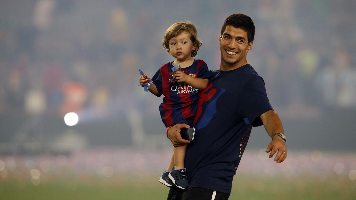 Barcelona's Luis Suarez holds his son Benjamin at the Camp Nou