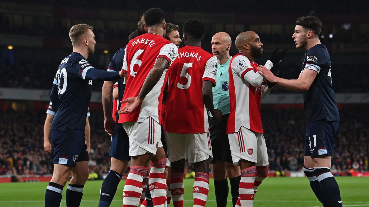 Players surround English referee Anthony Taylor (3rd R) during the English Premier League football match between Arsenal and West Ham United at the Emirates Stadium in London on December 15, 2021