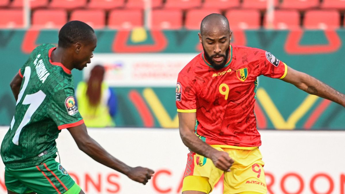 Guinea forward Jose Kante (R) fights for the ball with Malawi defender Gomezgani Chirwa