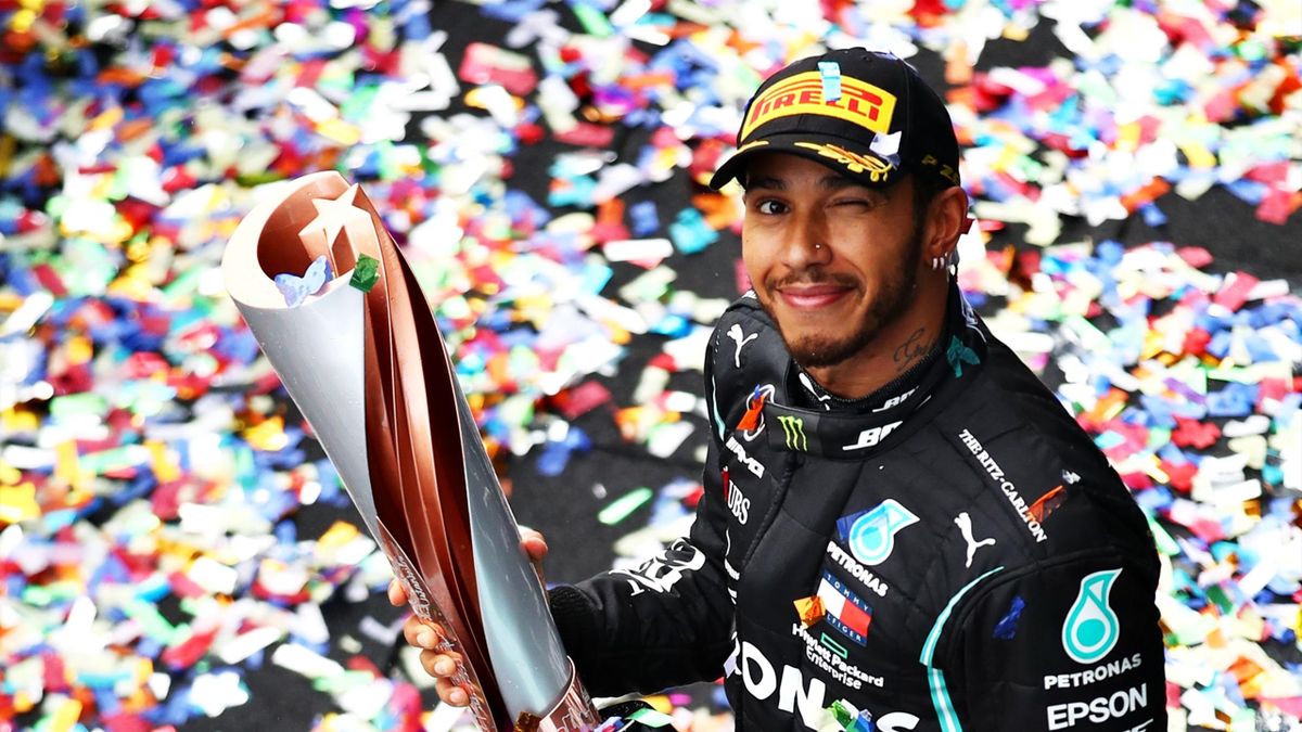 Race winner Lewis Hamilton of Great Britain and Mercedes GP celebrates winning a 7th F1 World Drivers Championship as he walks onto the podium, applauded by third placed Sebastian Vettel of Germany and Ferrari during the F1 Grand Prix of Turkey