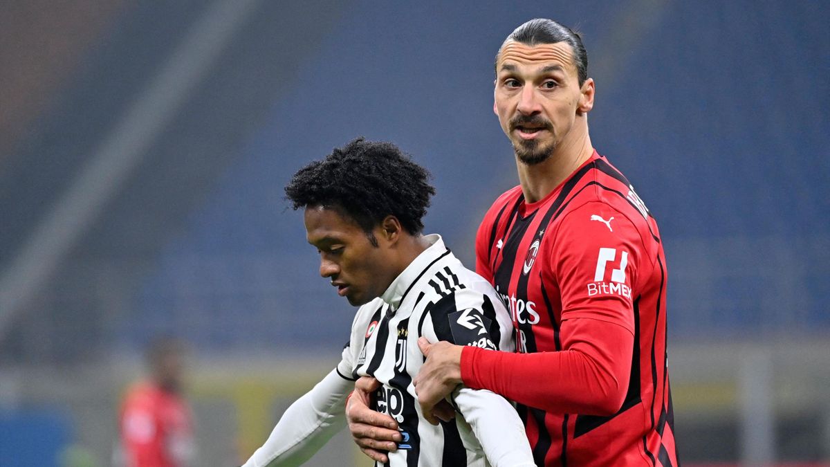 AC Milan's Swedish forward Zlatan Ibrahimovic holds back Juventus' Colombian midfielder Juan Cuadrado (L)