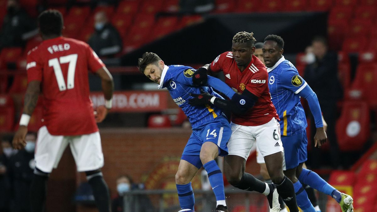 Adam Lallana of Brighton & Hove Albion battles for possession with Paul Pogba of Manchester United