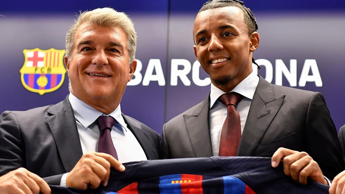 ules Kounde (R) poses for pictures holding his new jersey with Barcelona's Spanish President Joan Laporta during a press conference as part of his presentation ceremony at the Joan Gamper training ground in Sant Joan Despi, near Barcelona, on August 1, 20