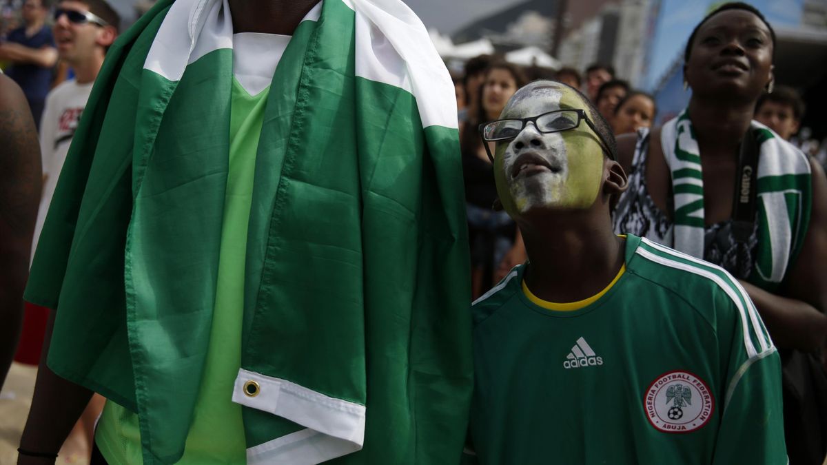 Nigeria football fans with flag watch a match