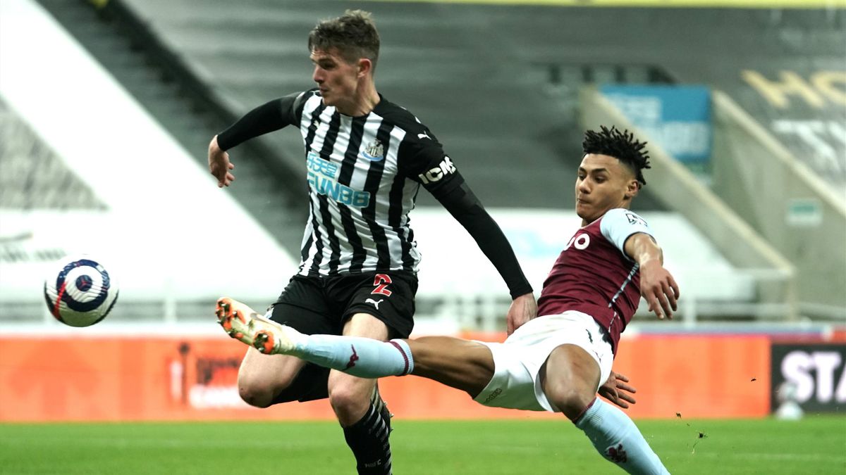 Ollie Watkins of Aston Villa stretches for the ball under pressure from Ciaran Clark of Newcastle United during the Premier League match between Newcastle United and Aston Villa at St. James Park on March 12, 2021 in Newcastle upon Tyne, England.