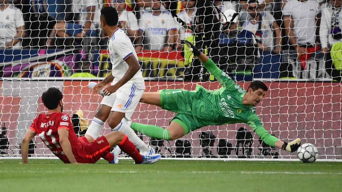 Real Madrid's Belgian goalkeeper Thibaut Courtois (R) makes a save from an attempt by Liverpool's Egyptian midfielder Mohamed Salah (L) during the UEFA Champions League final football match between Liverpool and Real Madrid at the Stade de France in Saint