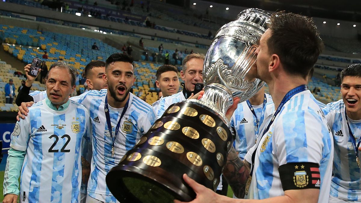 Lionel Messi of Argentina kisses the trophy as he celebrates with teammates after winning the final of Copa America Brazil 2021 between Brazil and Argentina at Maracana Stadium on July 10, 2021 in Rio de Janeiro, Brazil