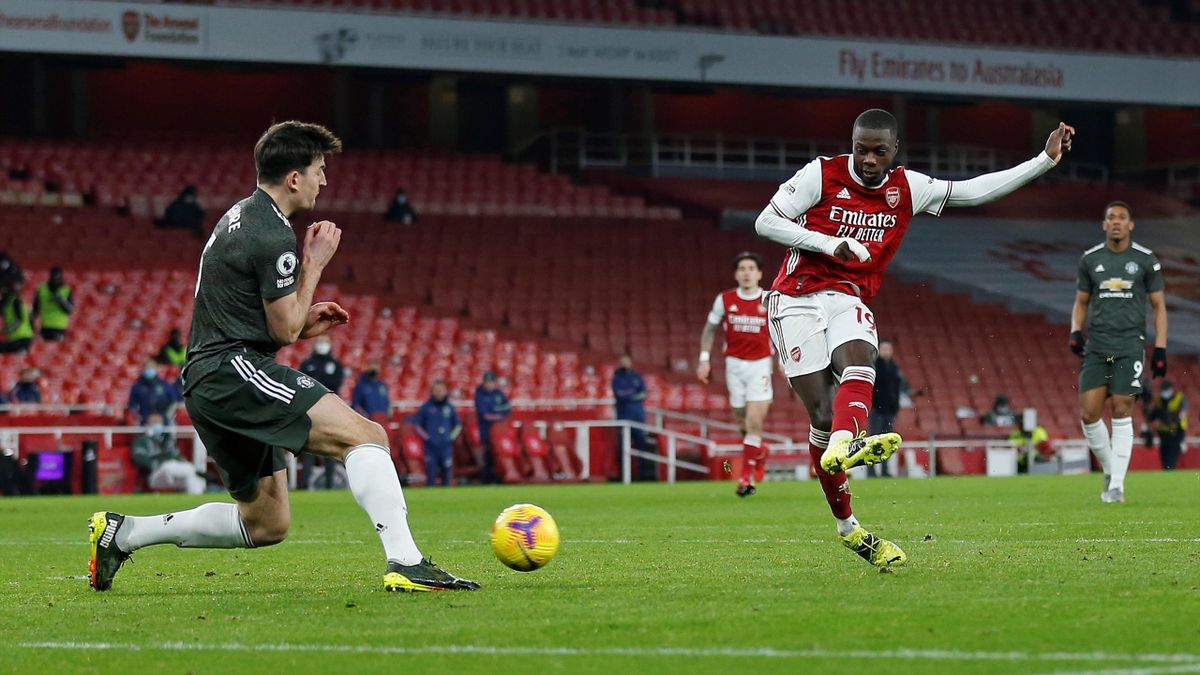 Manchester United's English defender Harry Maguire (L) blocks a shot from Arsenal's French-born Ivorian midfielder Nicolas Pepe during the English Premier League football match between Arsenal and Manchester United at the Emirates Stadium in London on Jan
