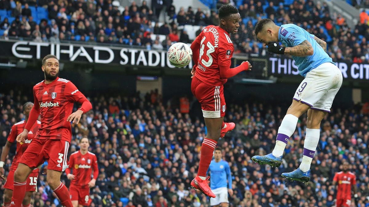 Manchester City's Brazilian striker Gabriel Jesus (R) jumps to head home their third goal during the English FA Cup fourth round football match between Manchester City and Fulham at the Etihad Stadium in Manchester, north west England, on January 26, 2020