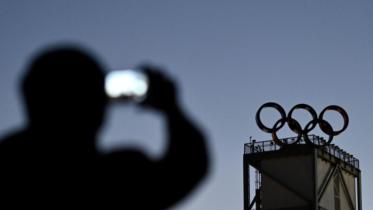 A visitor takes picture of the Olympic rings beside the Big Air Shougang, a venue of Beijing 2022 Winter Olympics, at Shougang Park on October 26, 2021 in Beijing, China.