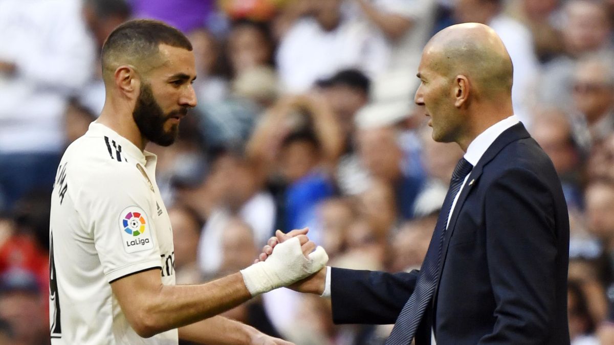 Real Madrid's French forward Karim Benzema (L) greets Real Madrid's French coach Zinedine Zidane as he leaves the pitch during the Spanish league football match between Real Madrid CF and RC Celta de Vigo at the Santiago Bernabeu stadium in Madrid on Marc