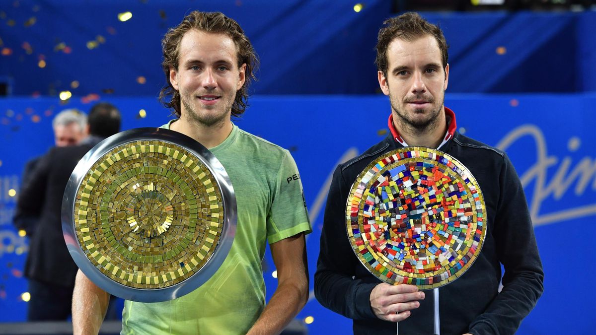 Lucas Pouille (L) and Richard Gasquet pose with their trophy after the final of the ATP World Tour Open Sud de France in Montpellier, southern France, on February 11, 2018