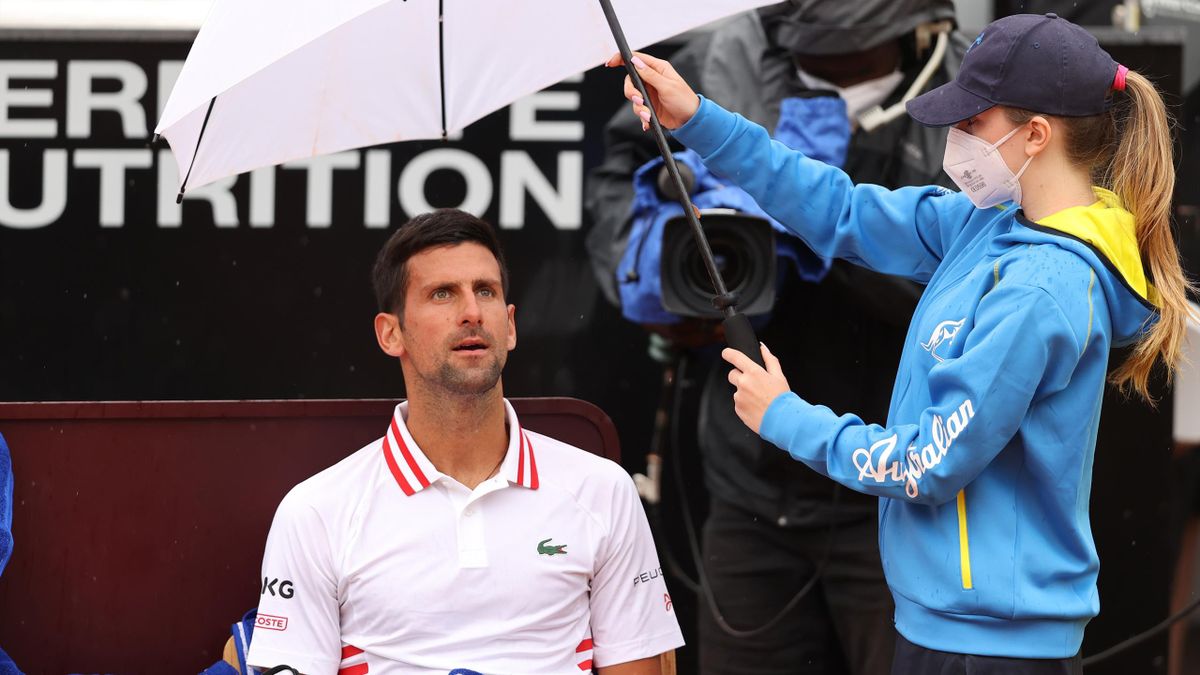 Novak Djokovic protégé par un parapluie lors de son match à Rome contre l'Américain Taylor Fritz, le 11 mai 2021 à Rome.