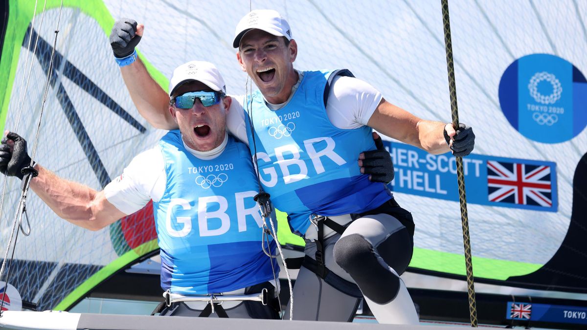 Dylan Fletcher (R) and Stuart Bithell of Team Great Britain celebrate winning gold in the Men's Skiff 49er class medal race on day eleven of the Tokyo 2020 Olympic Games