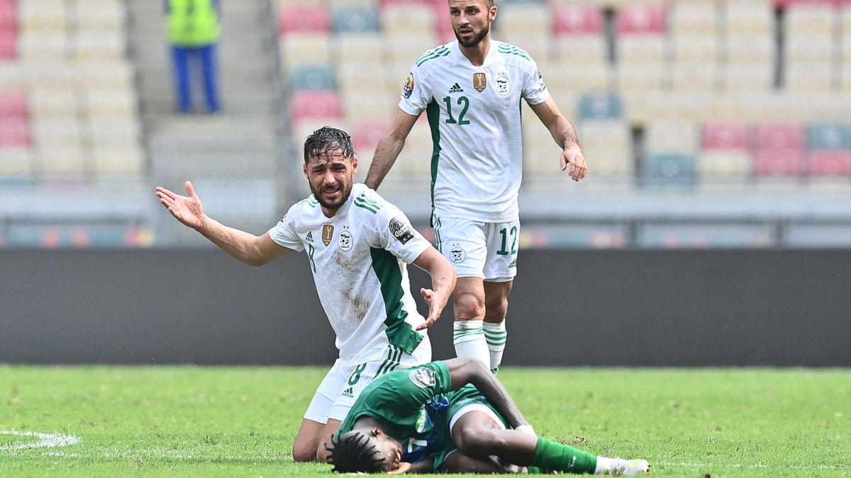 Sierra Leone's midfielder Kwame Quee (down) reacts on the ground next to Algeria's forward Youcef Belaili (L) during the Group E Africa Cup of Nations (CAN) 2021 football match between Algeria and Sierra Leone at Stade de Japoma in Douala on January 11, 2