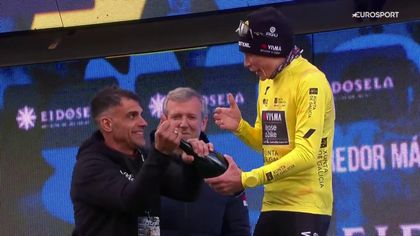 Tiritando de frío: Vingegaard no puede descorchar la botella en el podio y Pereiro le echa una mano